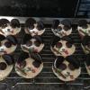 Panda style vanilla cupcakes with white chocolate topping,Oreo ears, minstrel eyes, mikado bamboo(with green candy belts as leaves), red candy belt tongue, and icing nose.