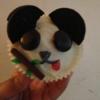 Panda style vanilla cupcakes with white chocolate topping,Oreo ears, minstrel eyes, mikado bamboo(with green candy belts as leaves), red candy belt tongue, and icing nose.